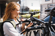 A cyclist adjusting the Frame Straps on their Thule OutWay Hanging bike rack