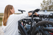 A cyclist securing a bike to the Thule OutWay Hanging rack with the lock feature