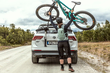 A cyclist loading their bike onto the Thule OutWay Platform boot mounted carrier